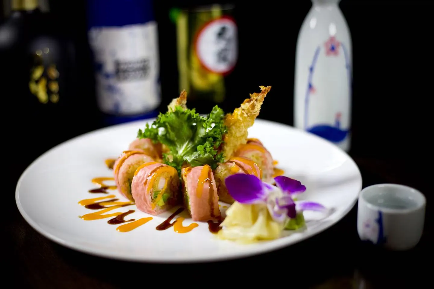 Pink wrapped tempura shrimp sushi roll with dual savory sauce and orchid garnish at Midori Sushi Of Highland Park, a Japanese Restaurant in Highland Park