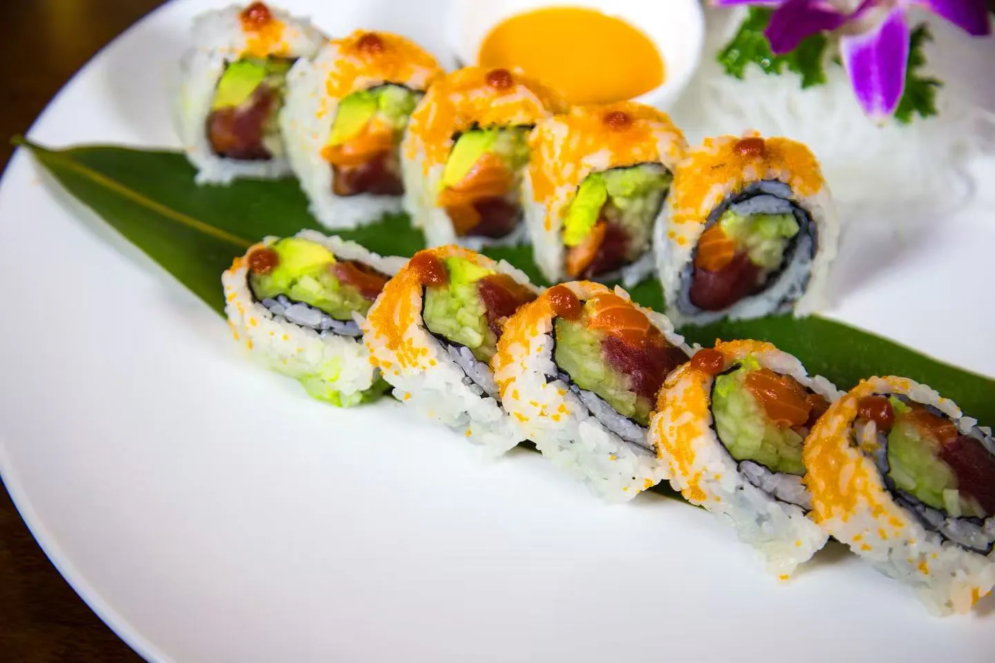 Multifish sushi roll coated with orange tobiko roe and fresh avocado at Midori Sushi Of Highland Park, a Japanese Restaurant in Highland Park