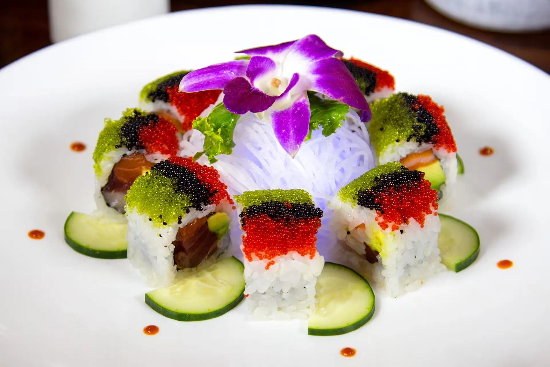 Colorful tobiko-topped premium sushi roll decorated with fresh cucumber slices at Midori Sushi Of Highland Park, a Japanese Restaurant in Highland Park